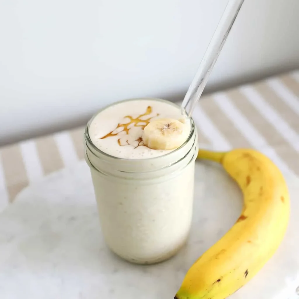 Creamy banana smoothie in a glass with honey drizzle