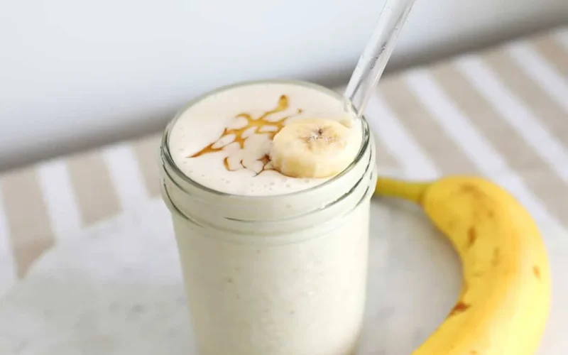 Creamy banana smoothie in a glass with honey drizzle