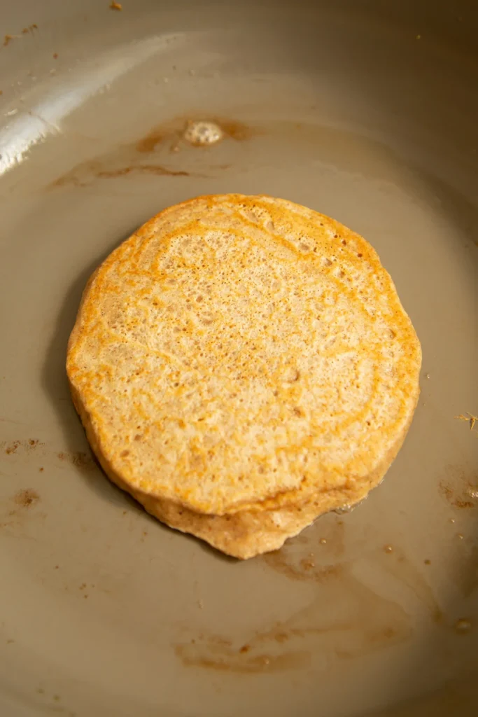 Golden protein pumpkin spice pancakes stacked on a plate