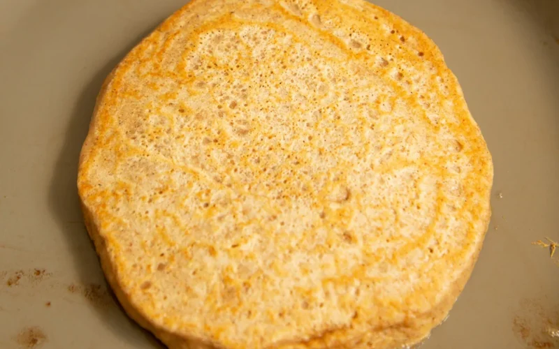 Golden protein pumpkin spice pancakes stacked on a plate