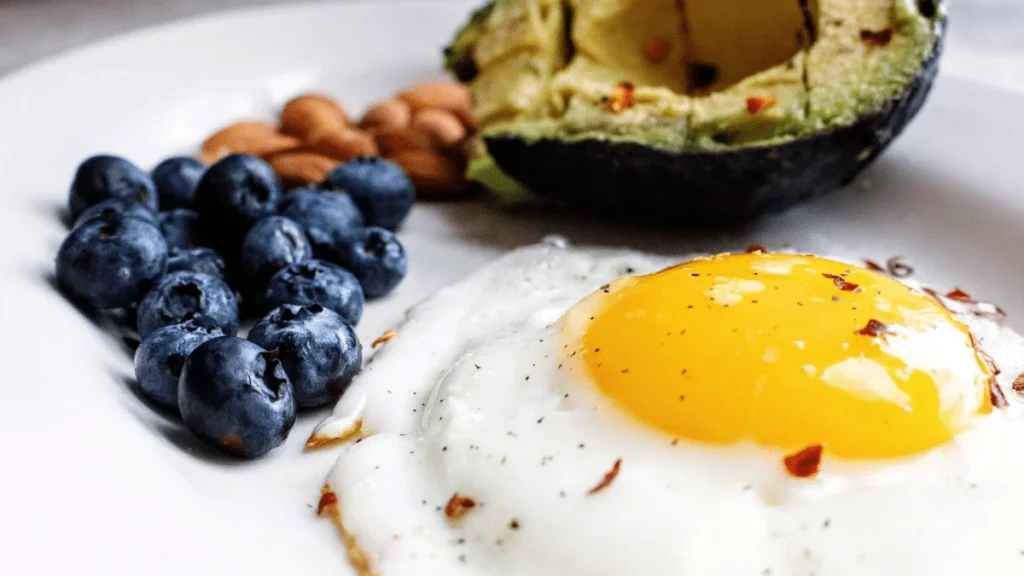 Healthy breakfast plate with egg blueberries almonds and avocado