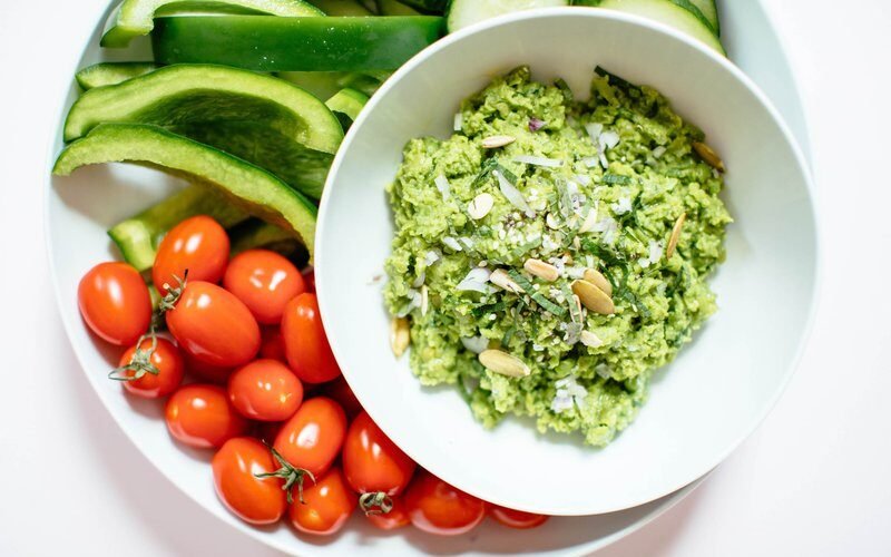 Close-up of blended pea and mint dip with fresh herbs