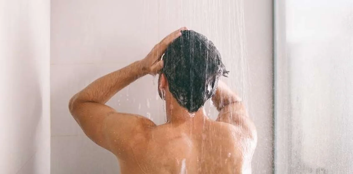 person taking a cold shower in a bathroom