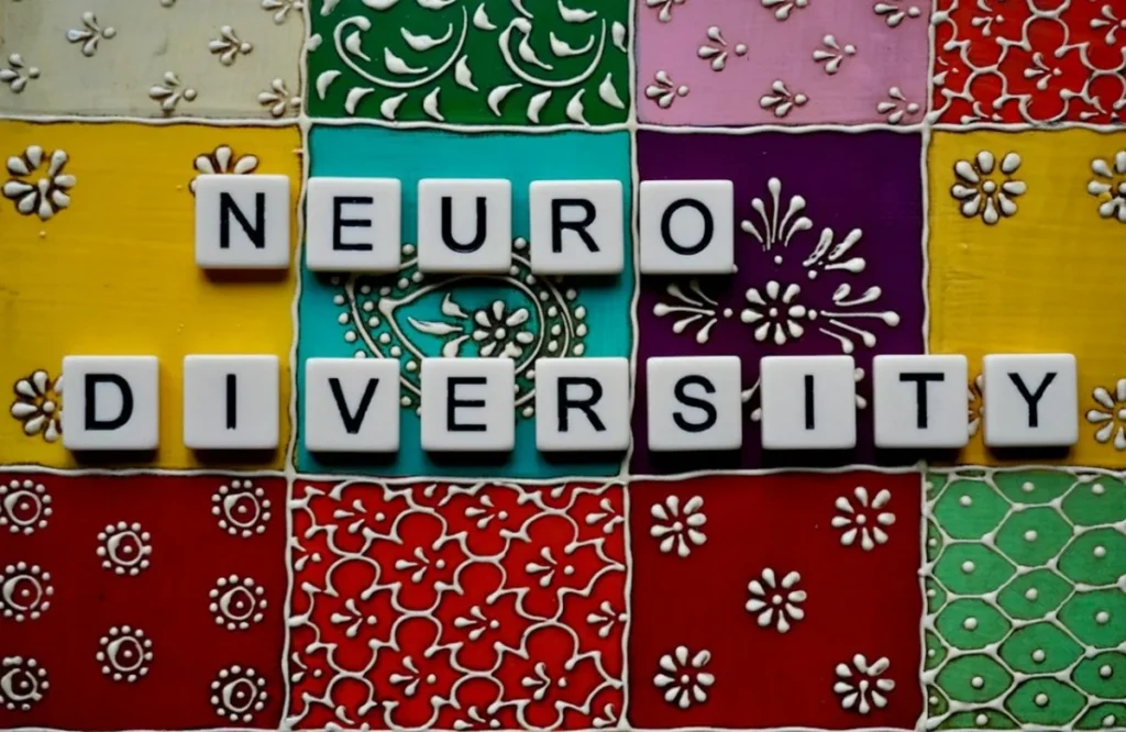 Scrabble tiles spelling 'neurodiversity' on colorful patterned background