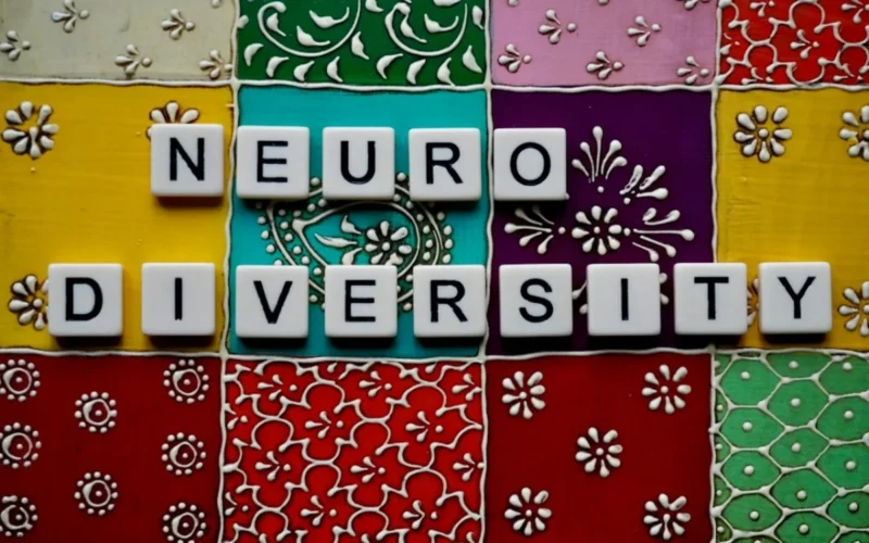 Scrabble tiles spelling 'neurodiversity' on colorful patterned background