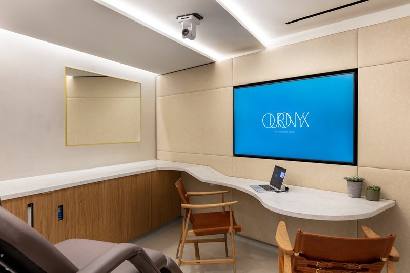 Clinic consultation room with curved desk and display screen